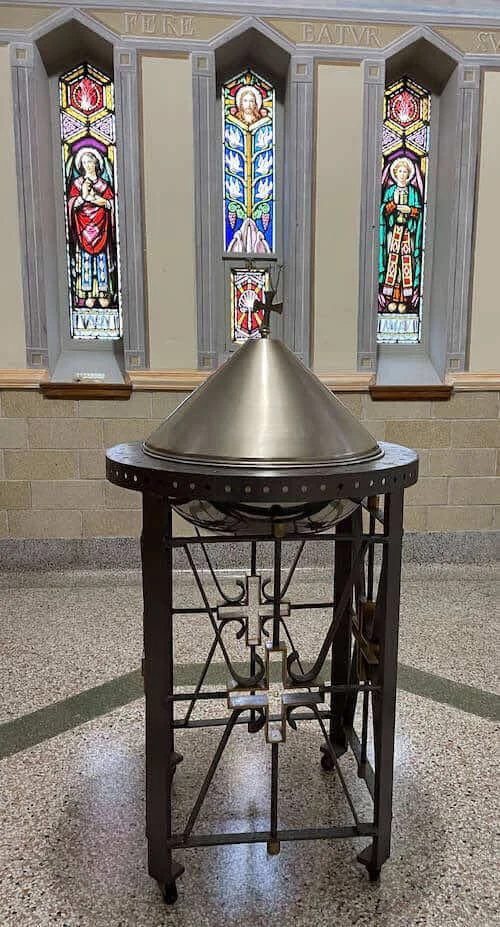 Fonts baptismaux devant les vitraux du baptistère